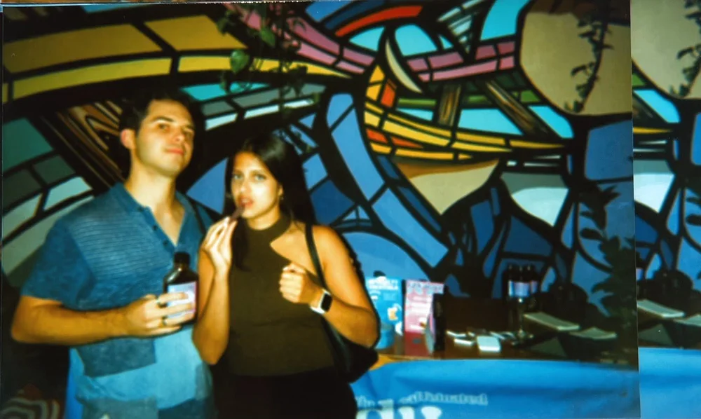 Couple at a bar with a stained glass mural, film photo