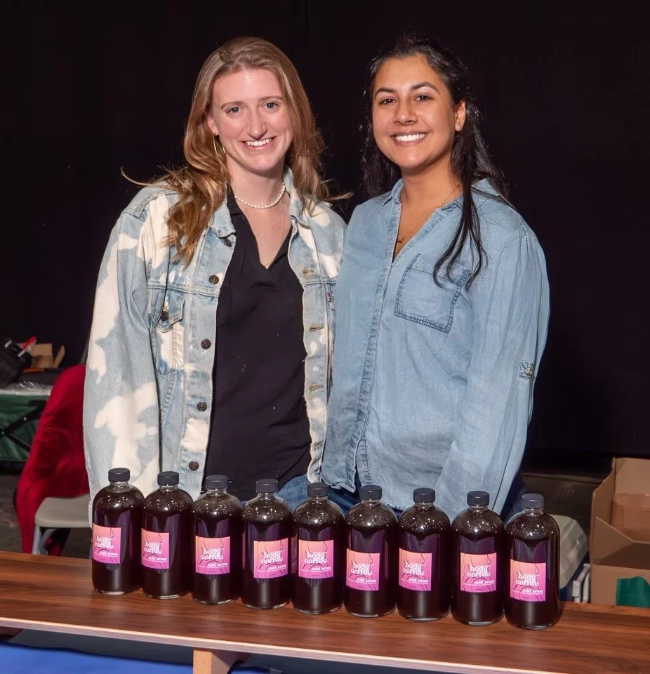 Daisy and Samar posing with a lineup of bottles