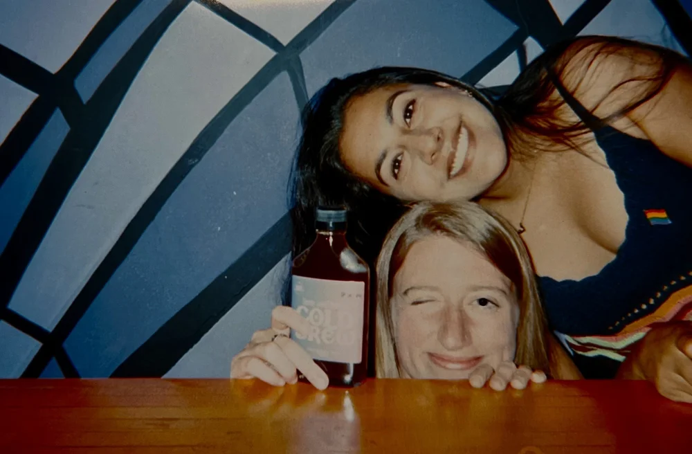 Two friends smiling at a bar, film photo